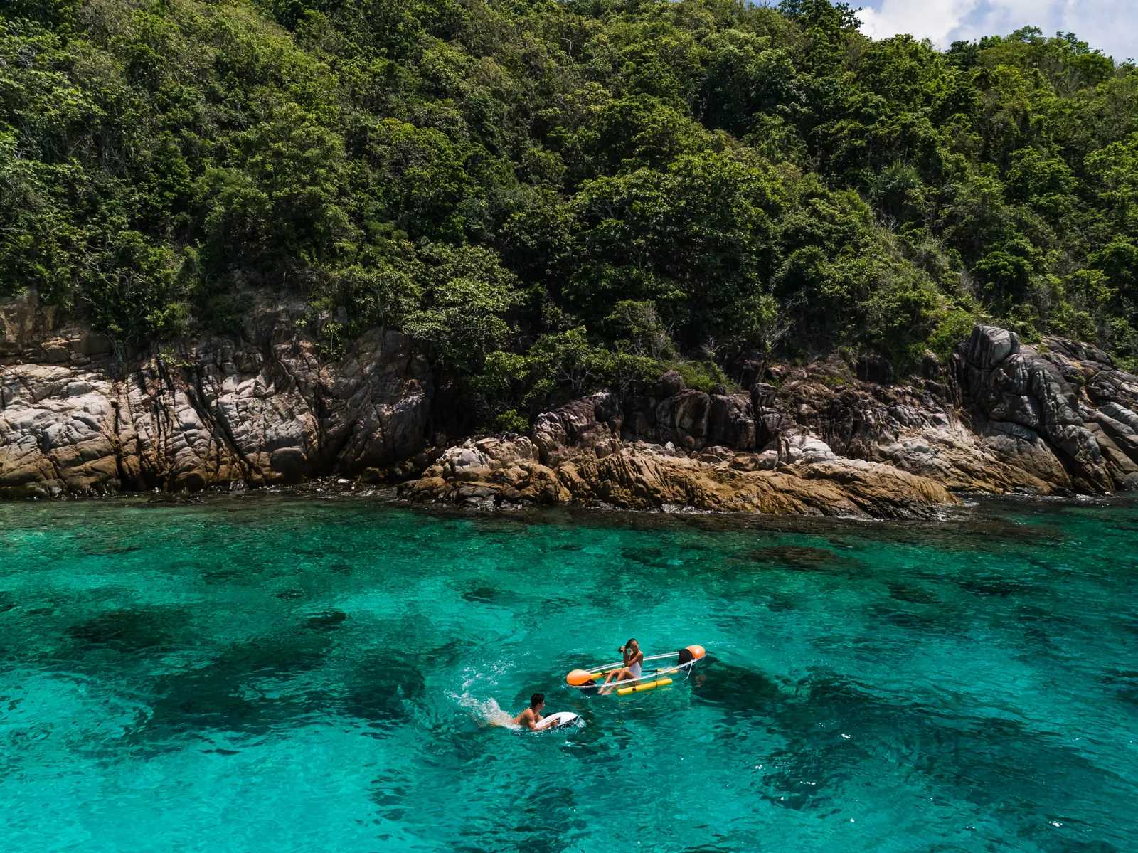 Kayaking in clear turquoise water beside an island